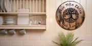 Fairy Tree Lodges Kitchen Area with wall mounted wooden crockery shelf and a plaque with text  Céad Míle Fálte  Oak Lodge