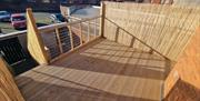 Raised outdoor patio overlooking a rear car parking area.