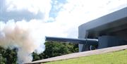 a photograph of the canon firing with a cloud of smoke at the front