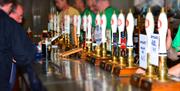 A bar with a row of hand pumps behind it