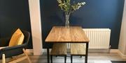 A kitchen bench set with a vase full of flowers.