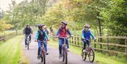 Happy family of 5 cycling on the grounds of Blessingbourne Estate