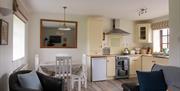 Kitchen and dining area with table and 4 chairs and mirror on the wall