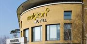 A view of the top rounded wall and sign of the Maldron hotel at Belfast international airport.