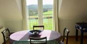 A view of the hills through balcony doors in the dining area.