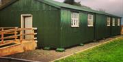 Photo of green hut exterior where some of the museum displays are featured