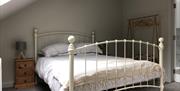 Bed, bedside cabinets, lamps and wardrobe in bedroom at The Heagry