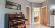 Modern tiled hallway with piano and good lighting