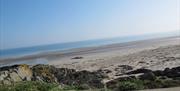 a photo of a sandy beach with some rocks