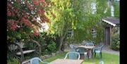 Image shows garden area with table and chairs