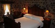 Image shows double bedroom with side tables and lamps