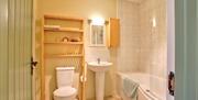Bathroom with a toilet, sink and a bath/shower.