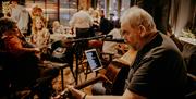 a man plays a guitar to people in a restaurant