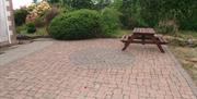 Paved garden and picnic bench outside the house