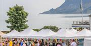 People browsing busy outdoor market stalls