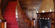 Curved carpeted wooden staircase beside a fireplace.