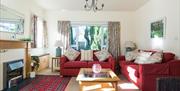 Living room with red sofas, a fireplace, coffee table and a large window.