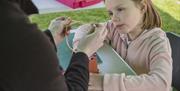 Little girl looking at glasswork crafts at Castle Ward