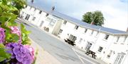 Image shows row of white cottages with picnic tables outside each one