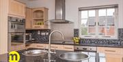 Image shows kitchen with all mod cons with a double sink   in island