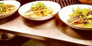 Seafood dish served with vegetables in white bowls at  Curran Court Hotel restaurant.