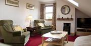 Image shows lounge area with armchairs and coffee table.