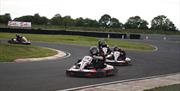 Four racers at each other's heels as they turn a corner on the track