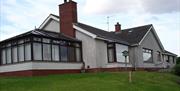 Image shows outside view of the property with sun room