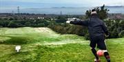 Image is of man playing footgolf in a field