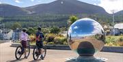 Cyclists on bikes from Bike Mourne, Newcastle admiring the Mourne Mountains from the Promenade, Newcastle, County Down