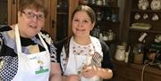 A lady and young girl pose beside their soda bread baking on the griddle