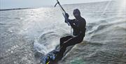 A close up of a kite surfer on the water