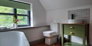 A bathroom with a bath, toilet and a sink.