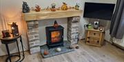 Woodburning fireplace and TV with Halloween decorations.