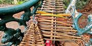 WILLOW CHRISTMAS TREES SITTING ON A GARDEN BENCH