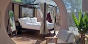 View of bedroom area from living room with chair and table with free standing mirror in view