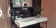private bathroom with large freestanding stone sink and heated mirror