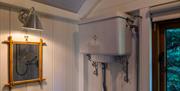 Hut ensuite, showing cistern and wall mirror