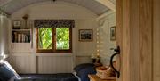 Hut interior showing king size bed and window to trees