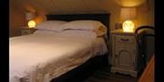 Image shows double bed with side tables and lamps