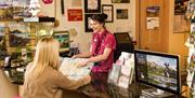 A photo of a Bangor Visitor Information Centre staff member helping a visitor