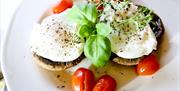 Poached eggs on mushrooms with tomatoes.