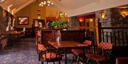 A restaurant dining area with tables, chairs and a seating booth.