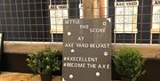 A sign with a slogan for Axe Yard Belfast.