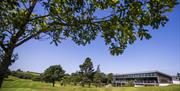 Image shows main building with golf course and trees