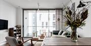 A view of the living room and a dining table with flowers.