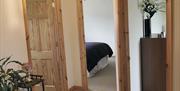 hallway into bedrooms with wooden doors