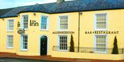 Outside image of The Inn with yellow walls and a black door