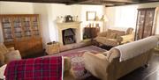 living area with cream sofas and armchair, fireplace and display cabinets