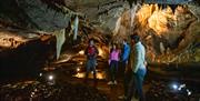 Group listens to their guide whilst underground at Marble Arch Caves